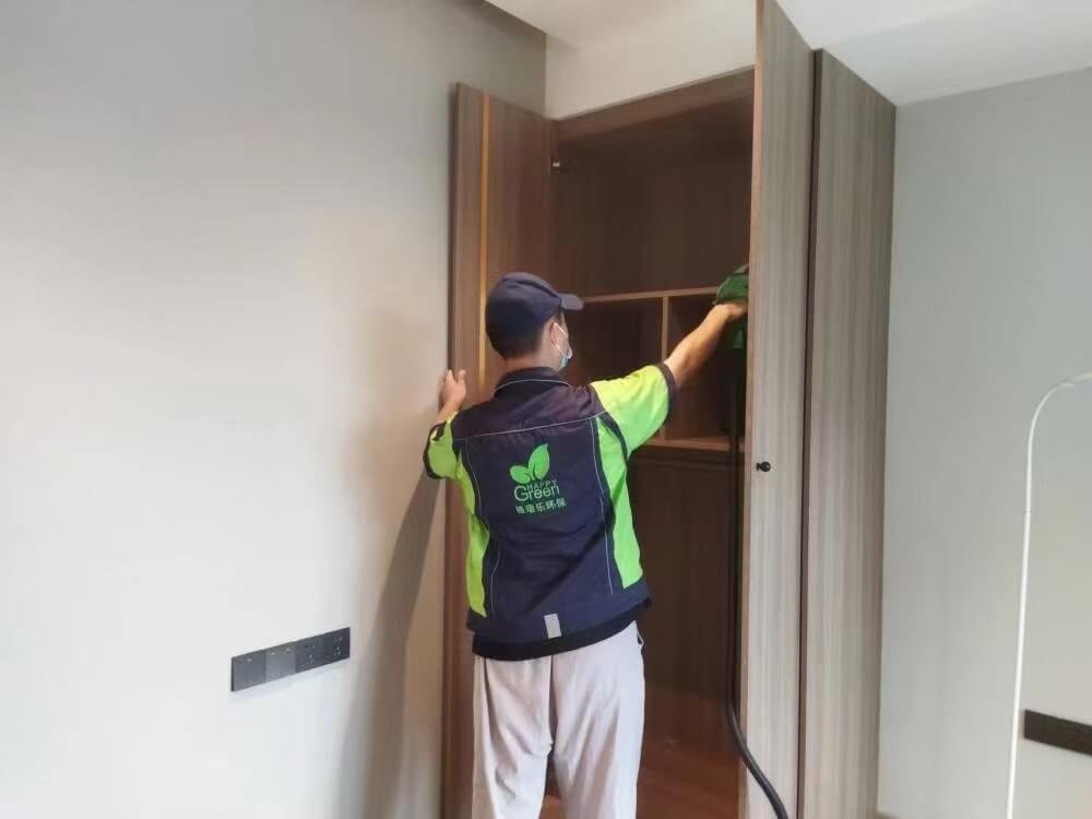 格瑞乐专业人员在走廊，拿着检测仪器对空气进行采样，旁边是刚处理完的鞋柜。